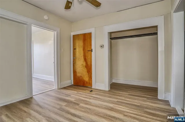 a view of empty room with wooden floor