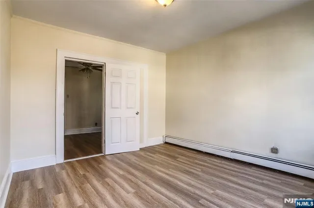 a view of an empty room with wooden floor