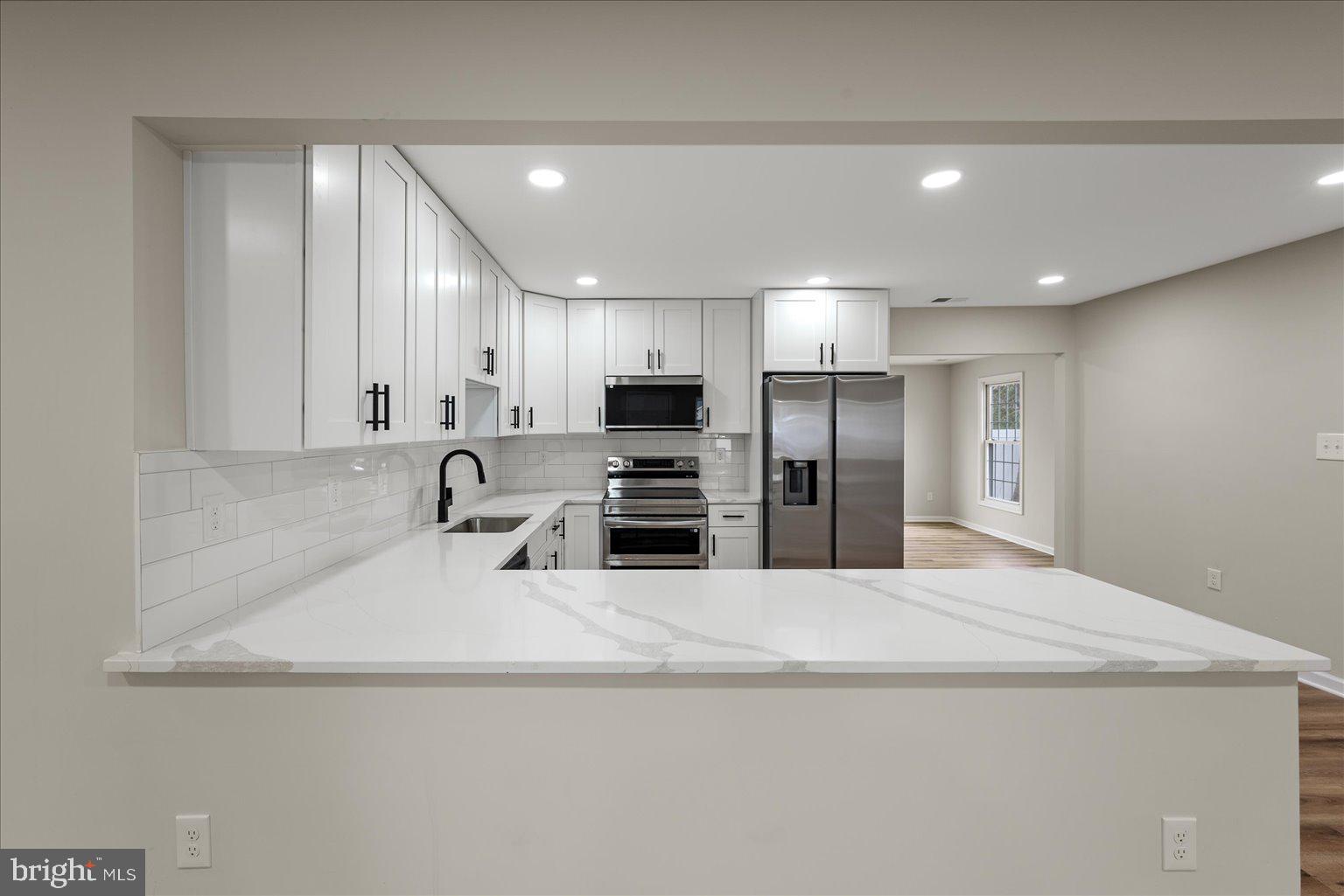 7931 Russell Road Alexandria, VA 22309 - Photo 3 of 16 a large kitchen with kitchen island a sink stainless steel appliances and cabinets