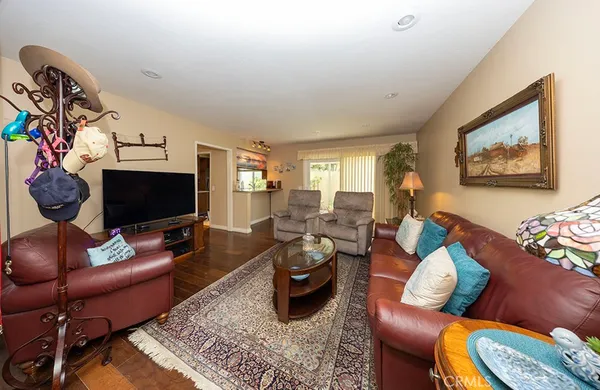 a living room with furniture a flat screen tv and a window