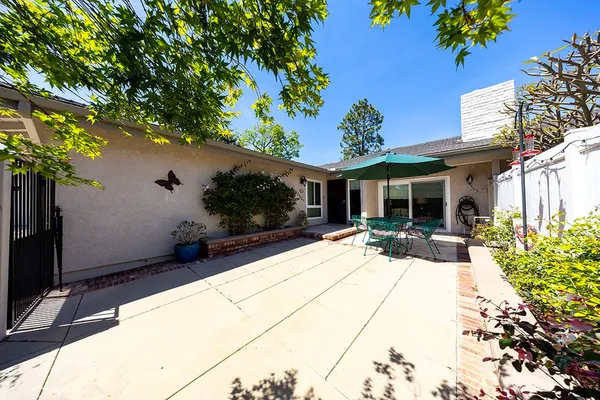 a view of a house with backyard sitting area and garden