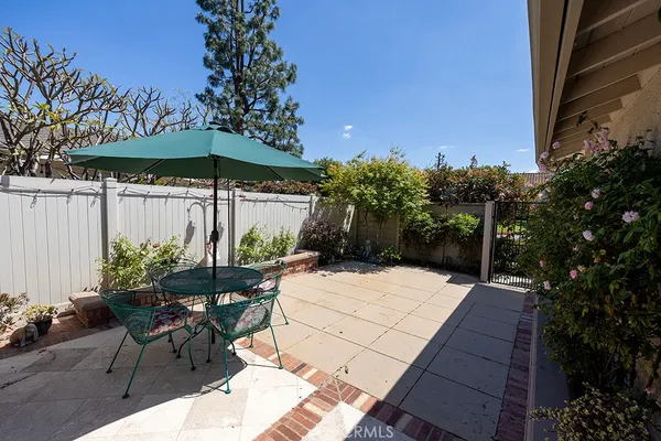 a patio with a table and chairs under an umbrella