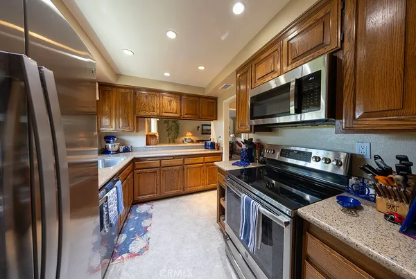 a kitchen with stainless steel appliances granite countertop a stove a sink and a microwave