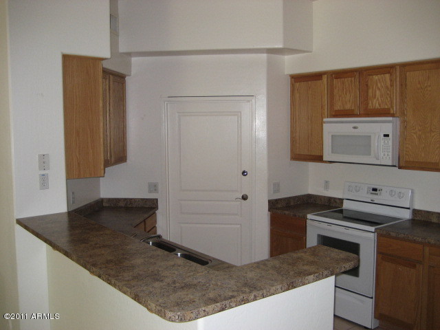 4488 East Thomas Road, Unit 1044 Phoenix, AZ 85018 - Photo 21 of 31 a kitchen with a sink and a stove top oven