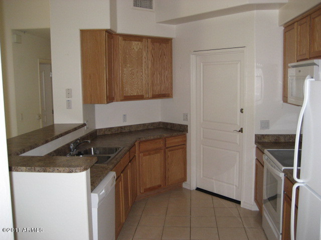 4488 East Thomas Road, Unit 1044 Phoenix, AZ 85018 - Photo 22 of 31 a kitchen with a sink and a refrigerator