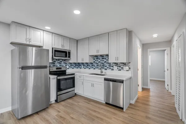 a kitchen with a refrigerator stove and wooden cabinets