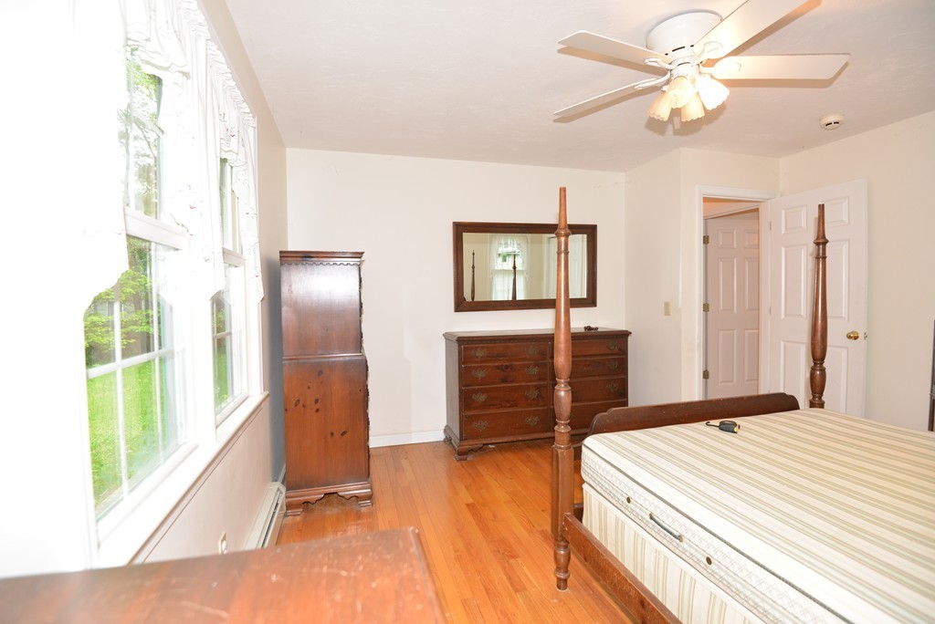 79 Converse Road Marion, MA 02738 - Photo 9 of 13 a spacious bedroom with a bed and a chandelier