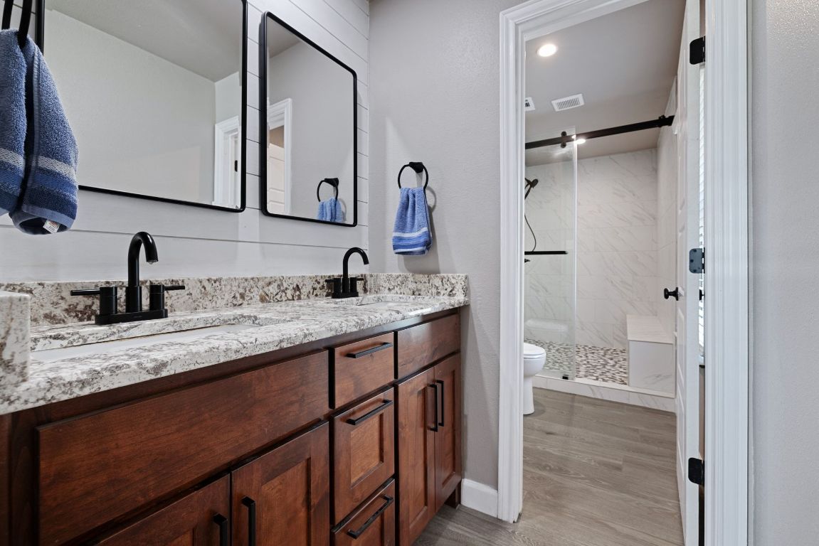 301 North 8th Street Jarrell, TX 76537 - Photo 19 of 27 a bathroom with a granite countertop sink a mirror and shower