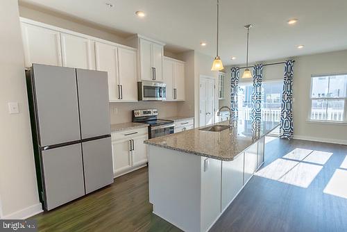 272 Sugar Maple Square Downingtown, PA 19335 - Photo 19 of 41 a kitchen with stainless steel appliances granite countertop a refrigerator a sink dishwasher a stove and a refrigerator with wooden floor