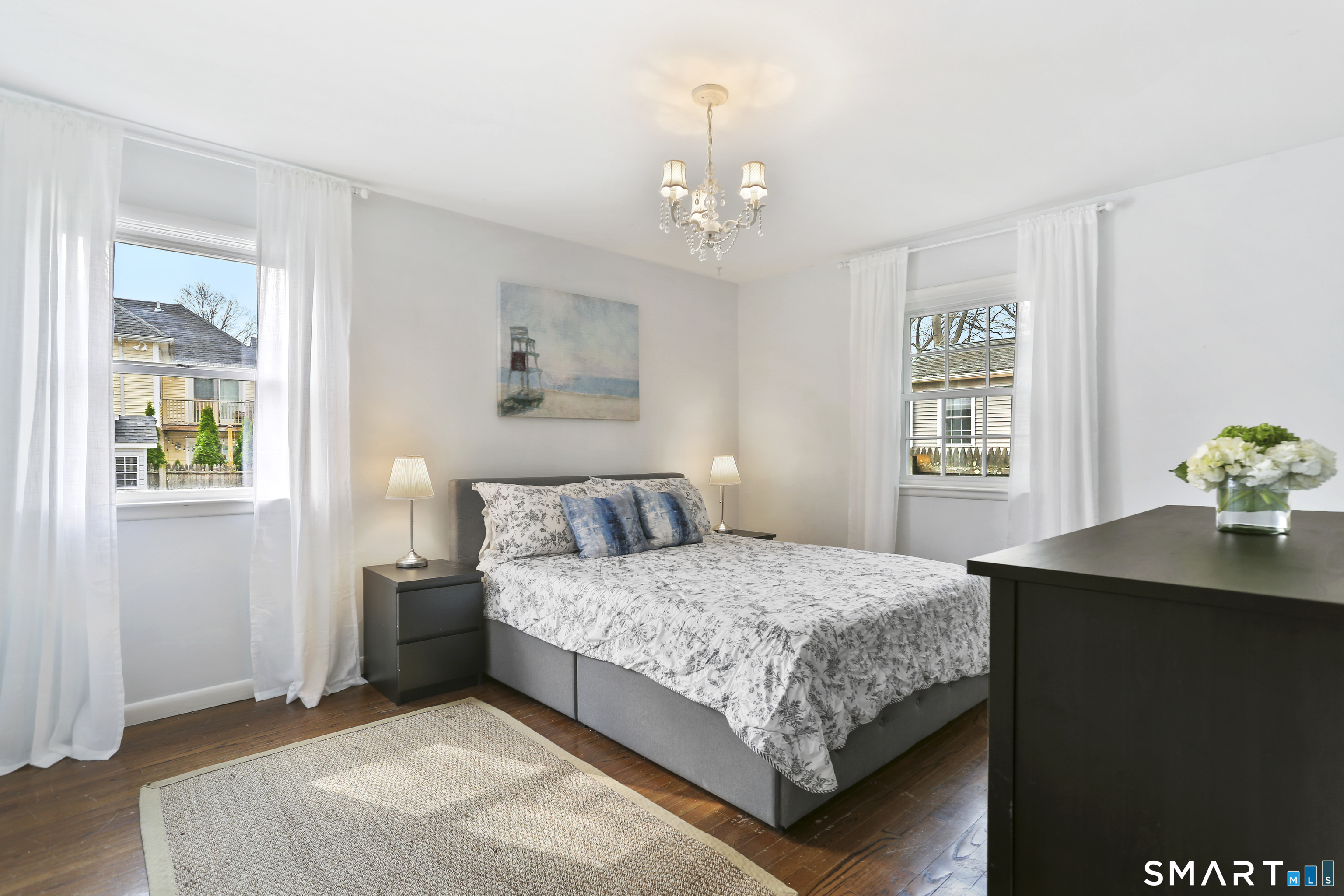 185 Windsor Road Fairfield, CT 06824 - Photo 15 of 41 a bedroom with a bed chandelier and a window