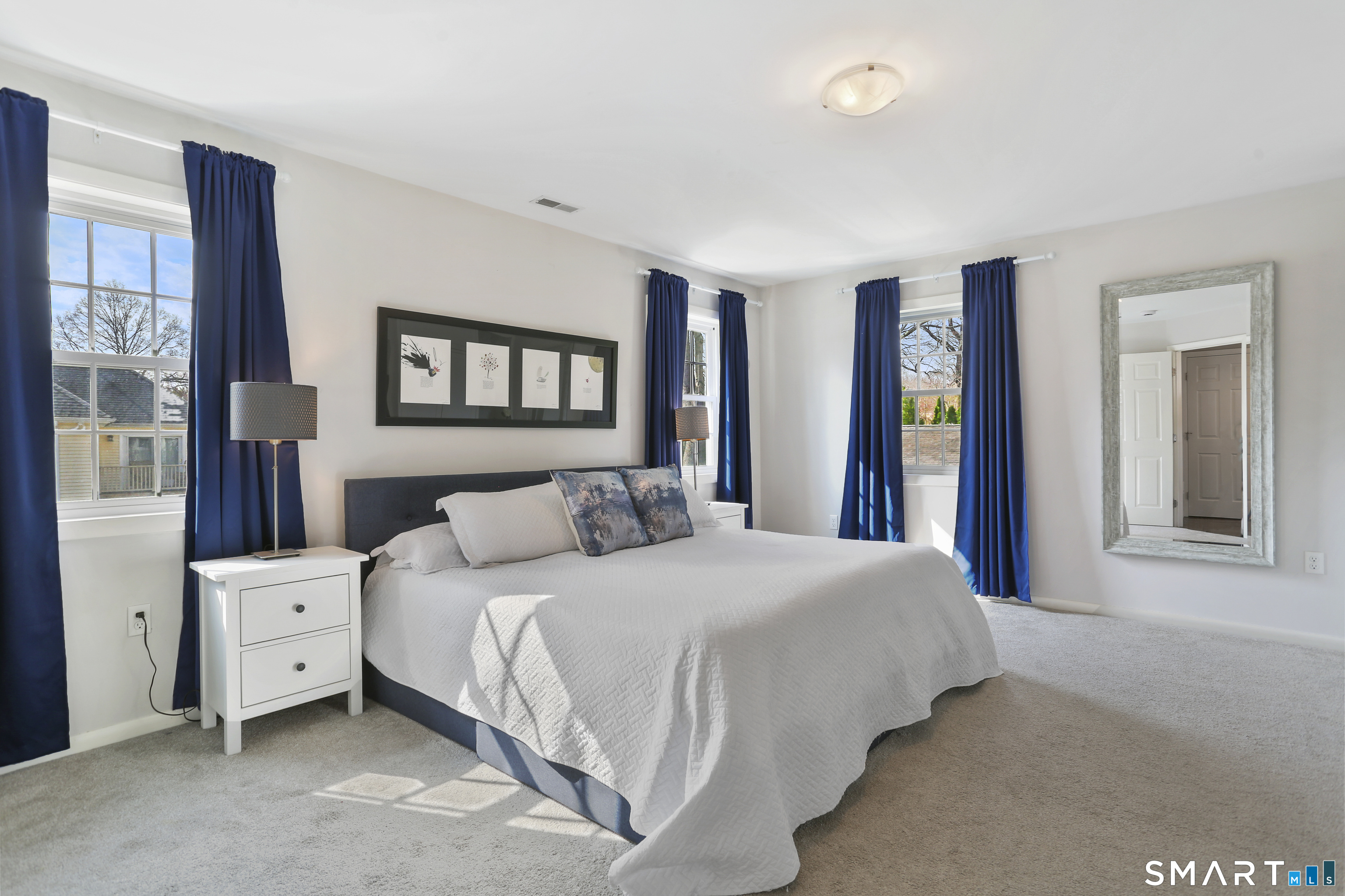 185 Windsor Road Fairfield, CT 06824 - Photo 22 of 41 a bedroom with a bed and a large mirror next to a window