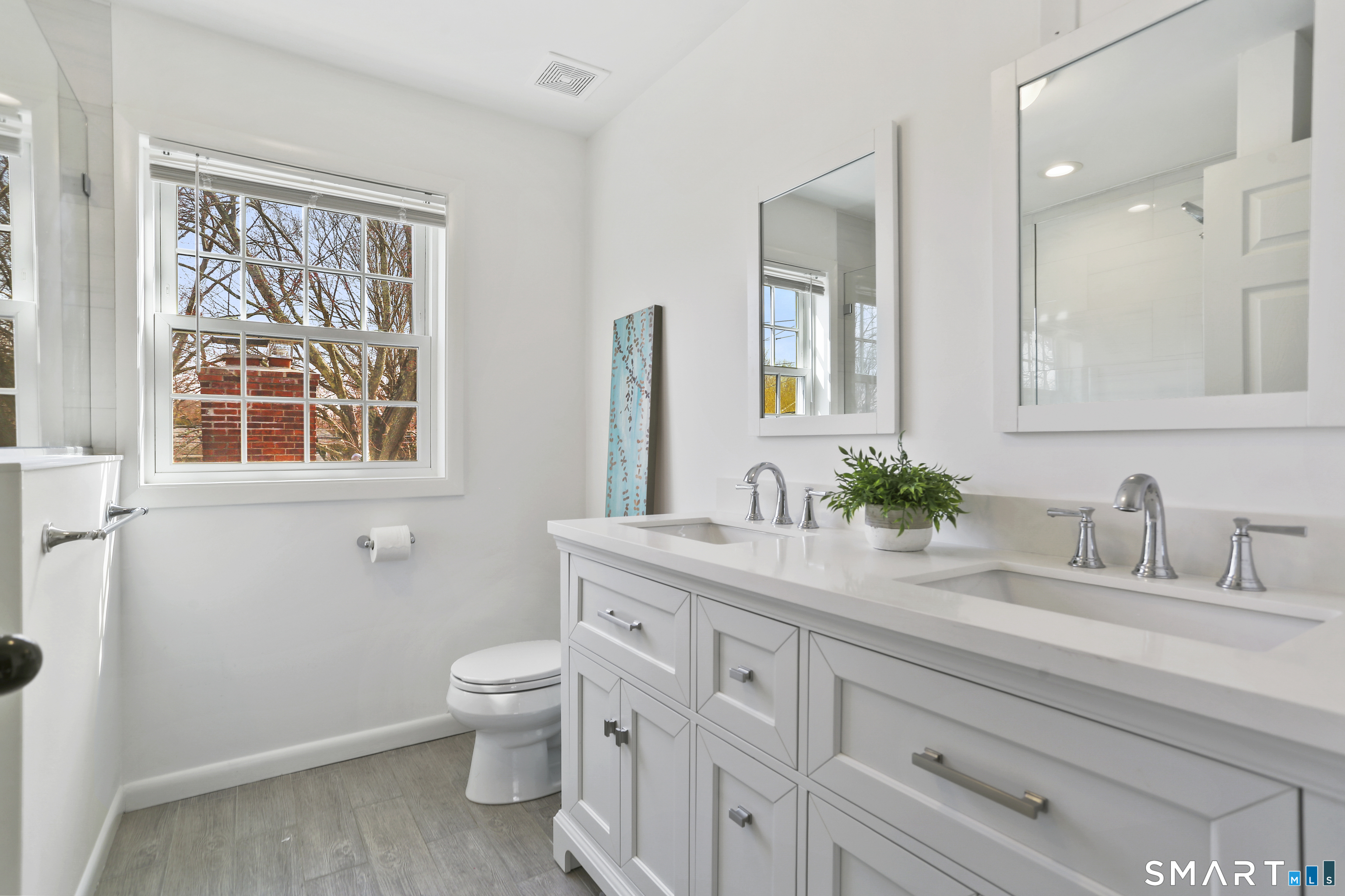 185 Windsor Road Fairfield, CT 06824 - Photo 24 of 41 a bathroom with a granite countertop sink a toilet and a mirror