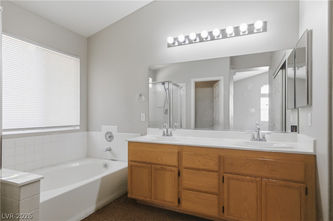 5100 Rancher Avenue Las Vegas, NV 89108 - Photo 18 of 26 Double vanity and a deep soaking tub create a luxurious primary bathroom oasis.