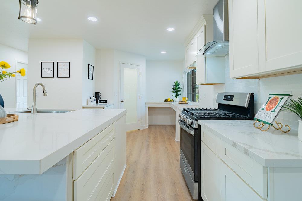 741 West 6th Street Gilroy, CA 95020 - Photo 14 of 29 a large white kitchen with stainless steel appliances granite countertop a lot of counter space and wooden floors