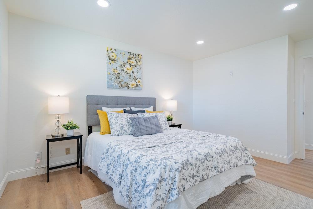 741 West 6th Street Gilroy, CA 95020 - Photo 19 of 29 a bedroom with a bed painting on wall and a wooden floor