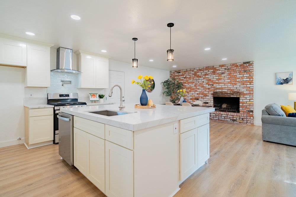 741 West 6th Street Gilroy, CA 95020 - Photo 9 of 29 a kitchen with stainless steel appliances kitchen island granite countertop a sink a stove and a wooden floors