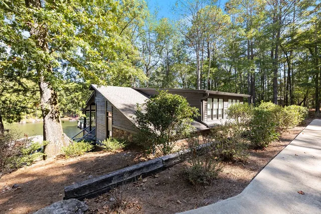 an aerial view of green landscape with trees houses and lake view