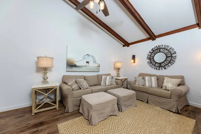 a living room with furniture and a wooden floor