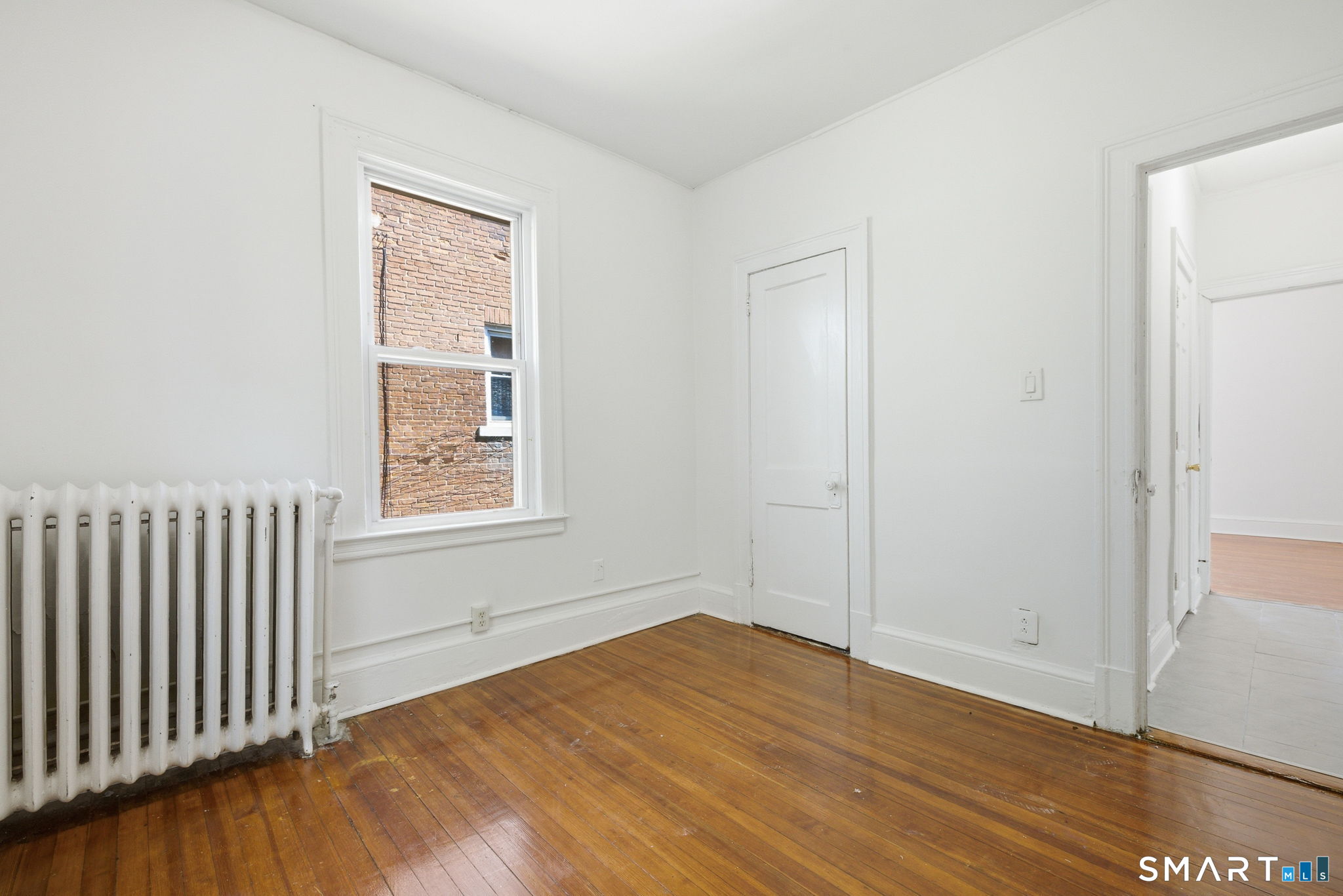 115 Baltimore Street, Unit 2 Hartford, CT 06112 - Photo 11 of 14 an empty room with wooden floor and windows