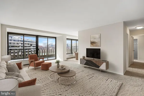 a living room with furniture floor to ceiling window and a flat screen tv