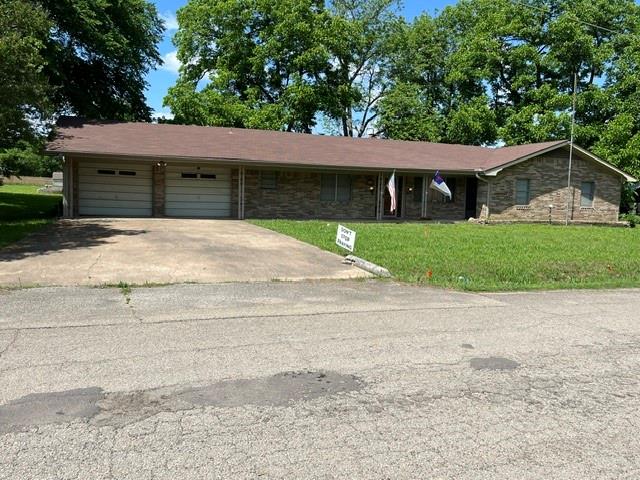 304 Sunset Street Roxton, TX 75477 - Photo 1 of 31 a front view of a house with a yard and garage