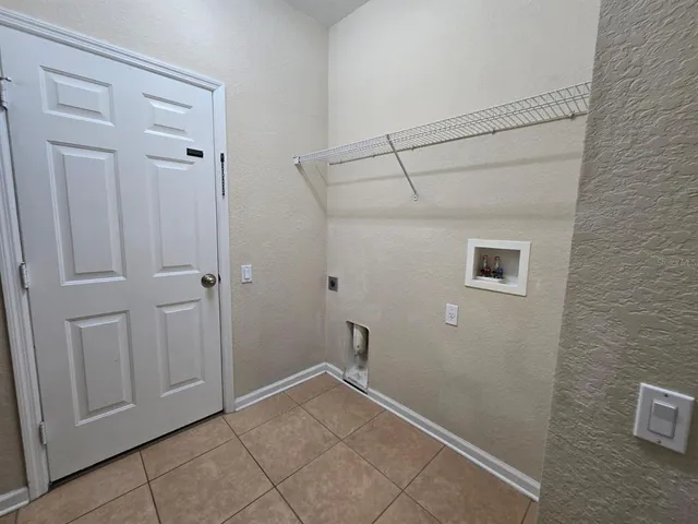 a view of a hallway with wooden floor and a bathroom