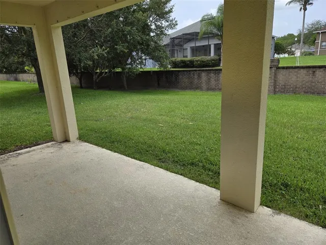 a view of a white house with a big yard and large tree