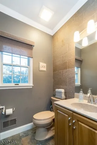 a bathroom with a granite countertop sink a toilet and a mirror