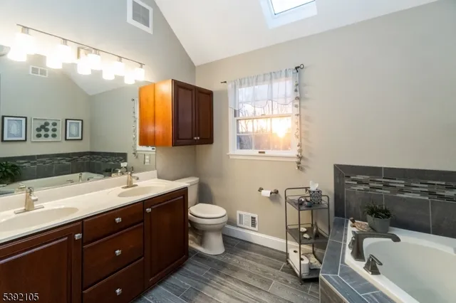 a bathroom with a tub sink toilet and mirror