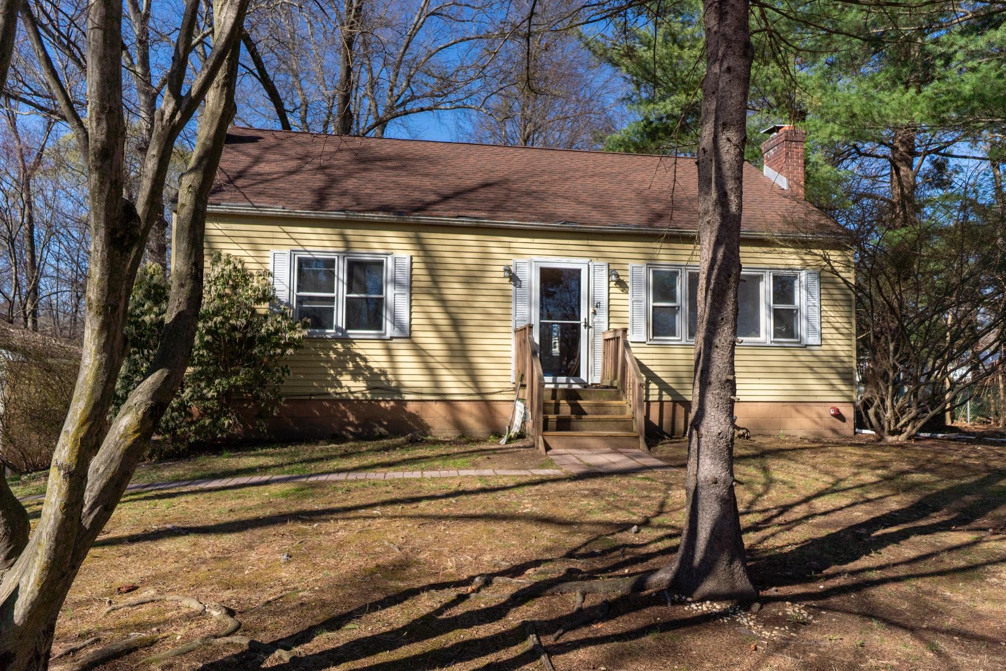 View of front the home with a chimney, a front yard, and entry steps