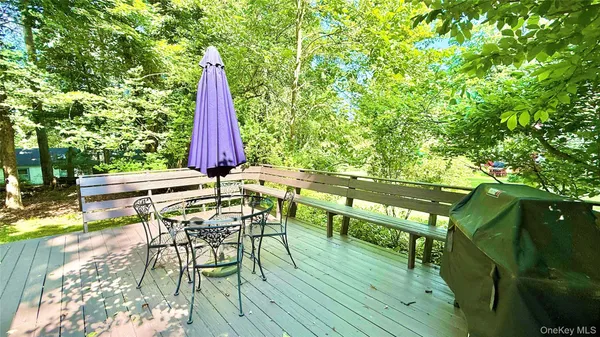 a view of deck with a table and chairs a barbeque with wooden floor and fence