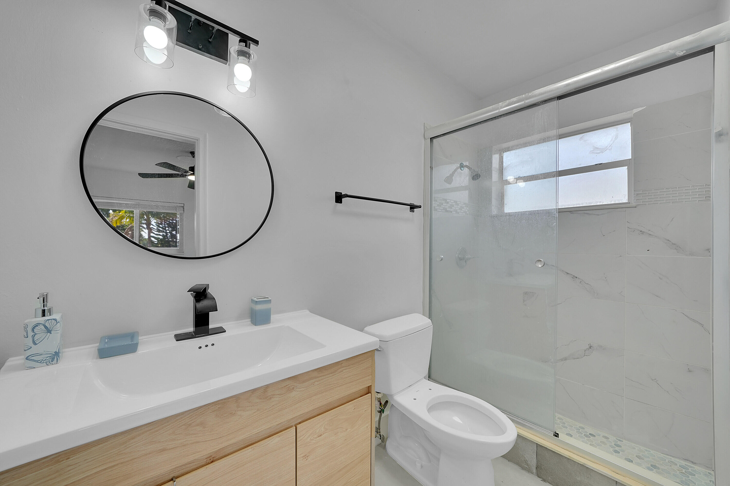 2821 Northeast 2nd Avenue, Unit 2823 Boca Raton, FL 33431 - Photo 12 of 38 a bathroom with a sink a mirror a toilet and a mirror