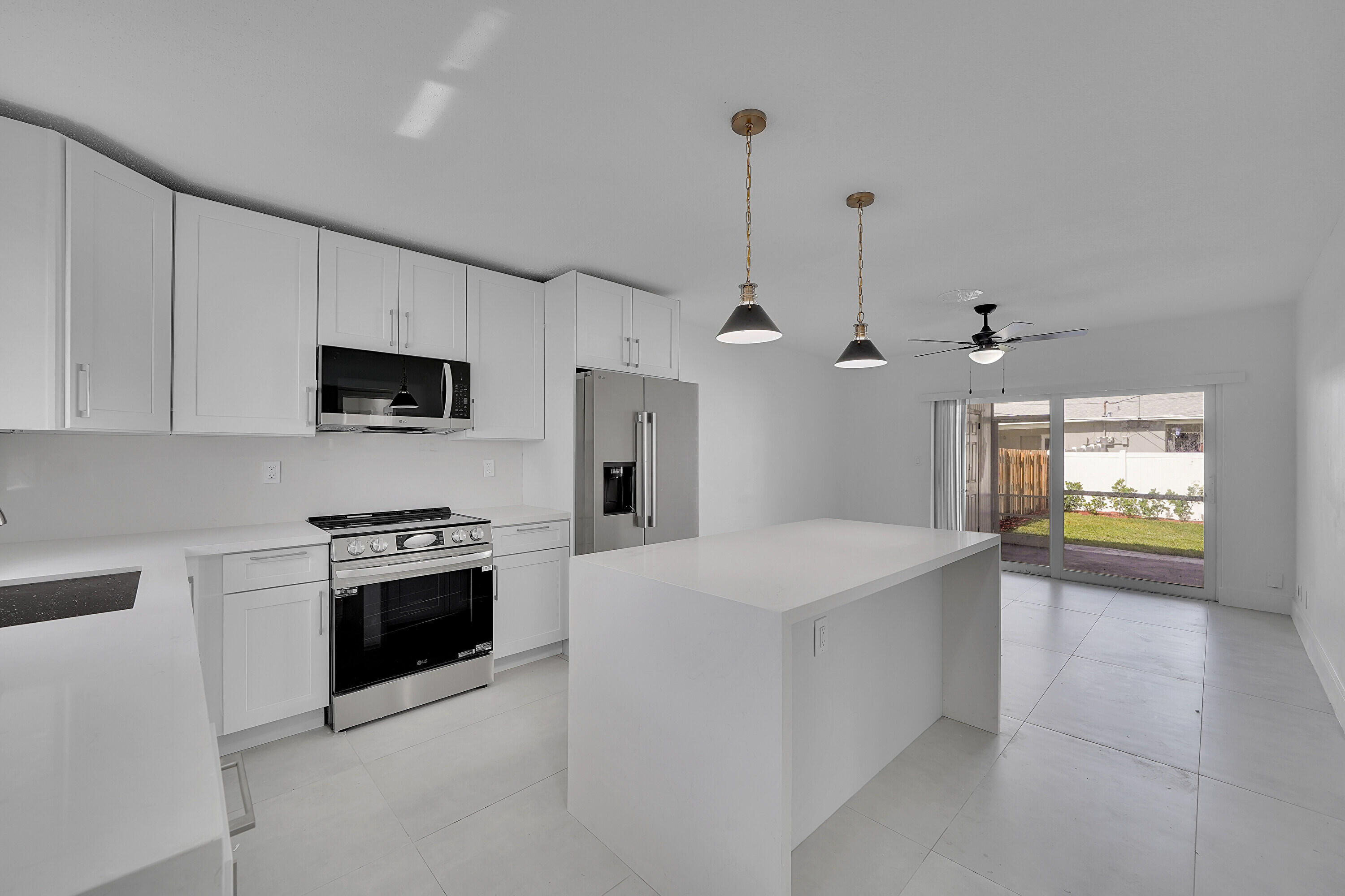 2821 Northeast 2nd Avenue, Unit 2823 Boca Raton, FL 33431 - Photo 5 of 38 a large kitchen with stainless steel appliances granite countertop a stove a sink and a refrigerator