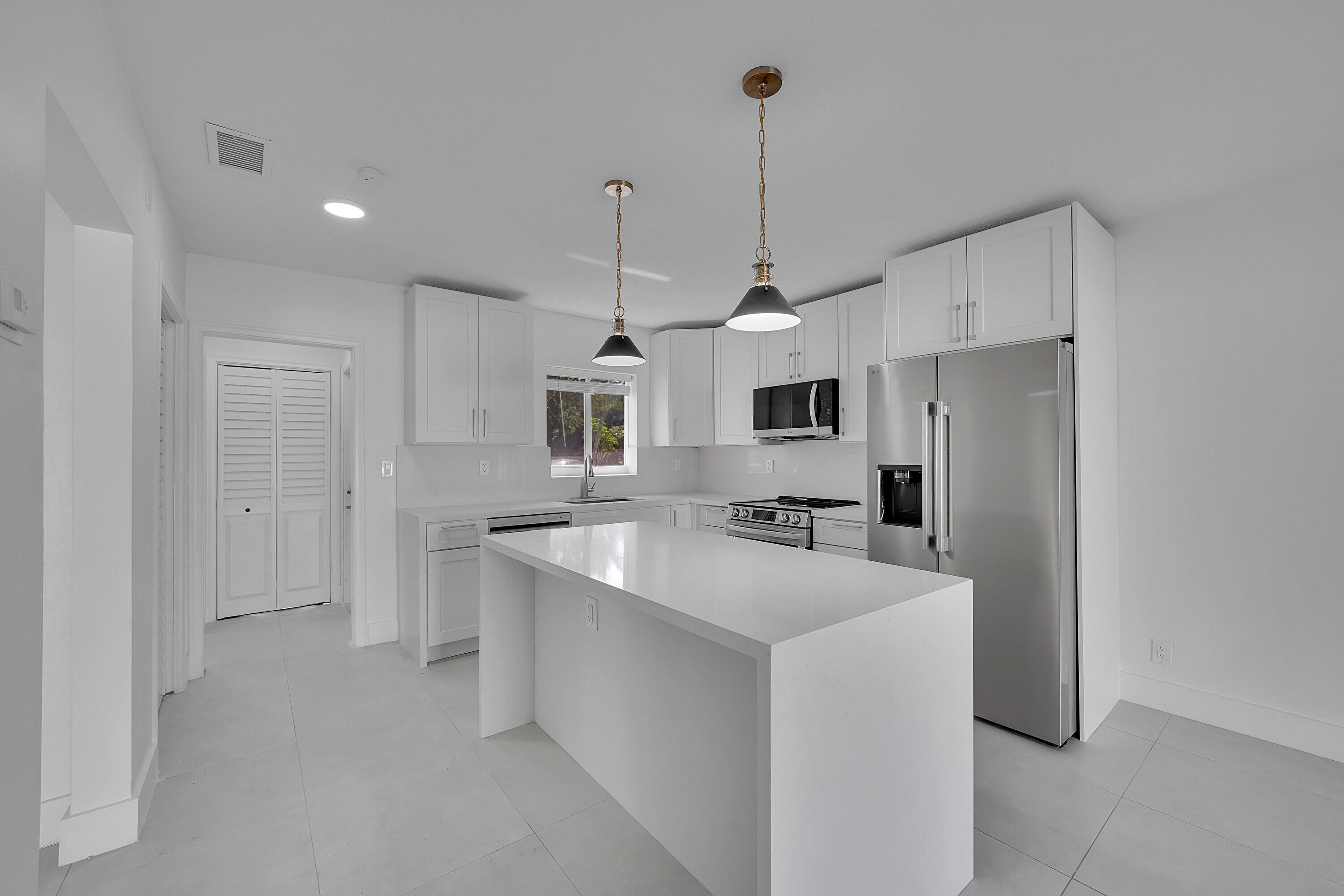 2821 Northeast 2nd Avenue, Unit 2823 Boca Raton, FL 33431 - Photo 6 of 38 a kitchen with stainless steel appliances a refrigerator sink and microwave