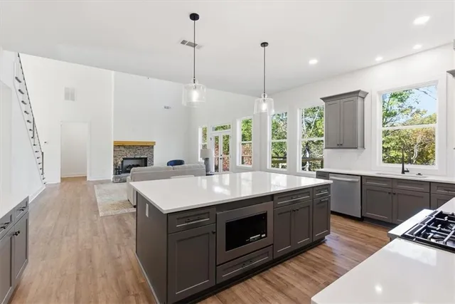 a kitchen with a stove sink and wooden floor