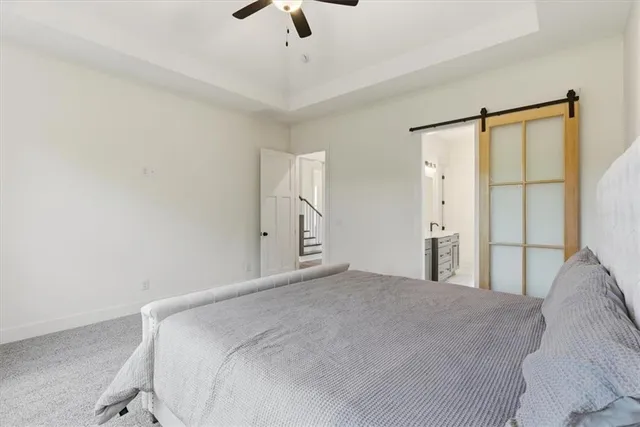 a bedroom with a large bed and a chandelier fan