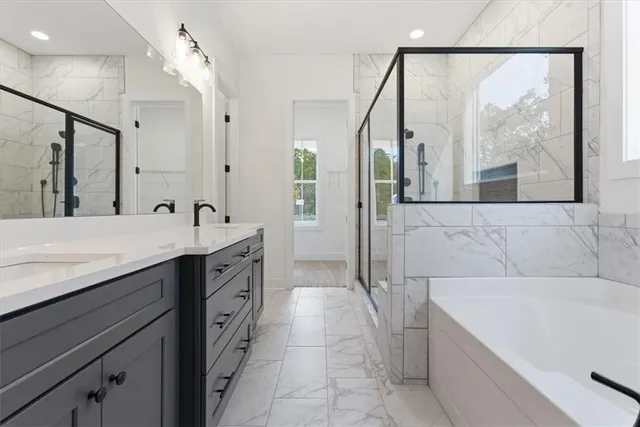 a spacious bathroom with a tub sink and mirror