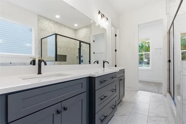 a bathroom with a double vanity sink a mirror and a shower