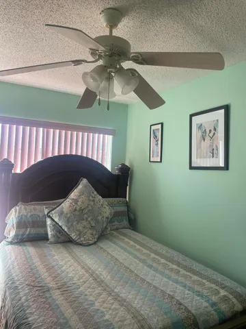 a bed sitting in a bedroom next to a window with a chandelier