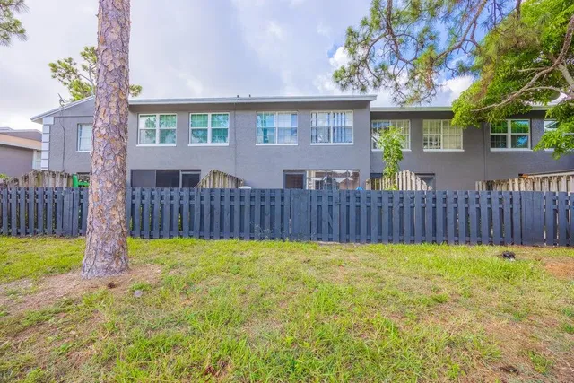 a view of a house with a yard and wooden fence