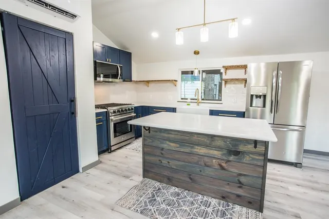 a kitchen with stainless steel appliances a refrigerator and a stove top oven