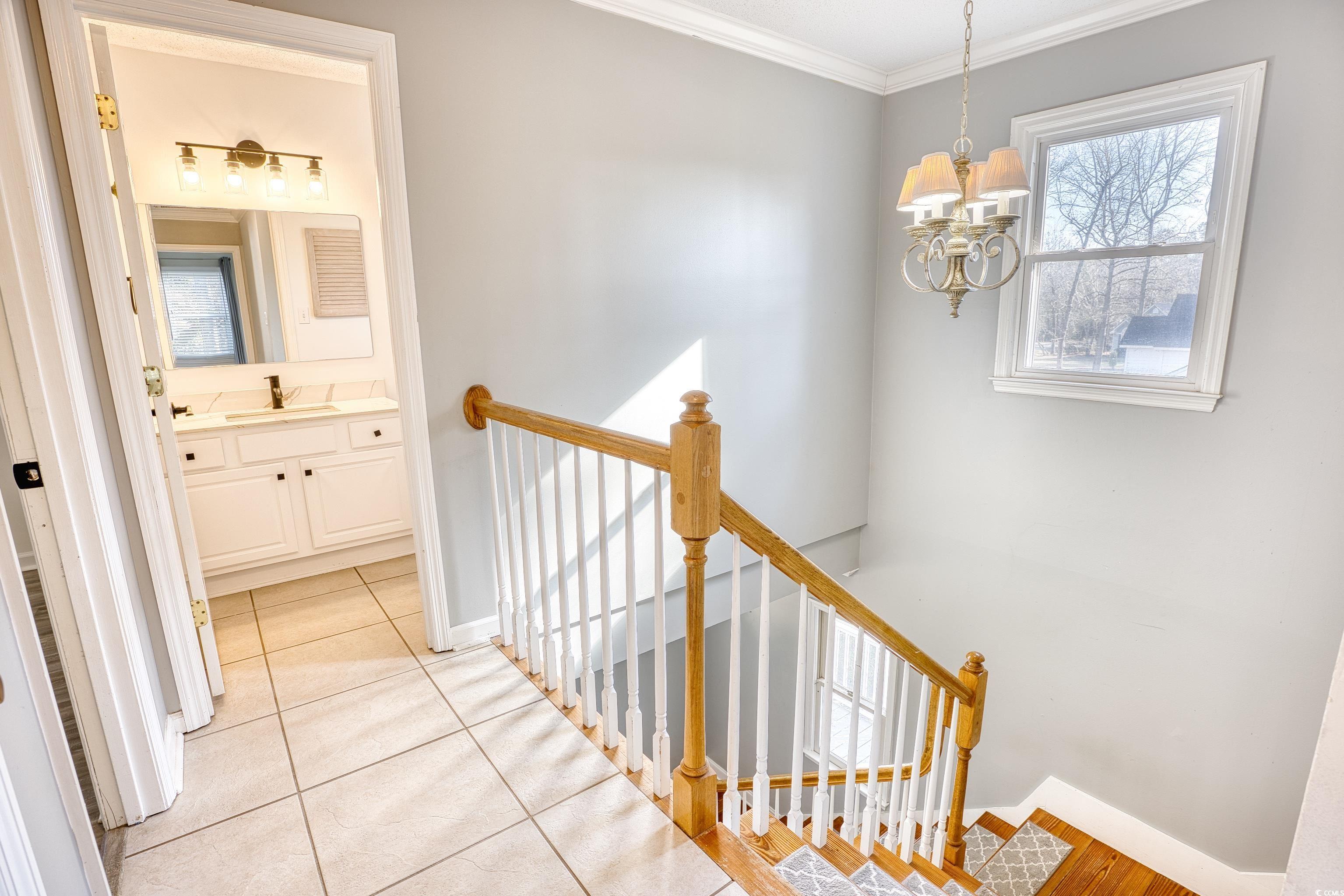 116 Great Lakes Road Pawleys Island, SC 29585 - Photo 18 of 37 Hallway with crown molding, a notable chandelier,