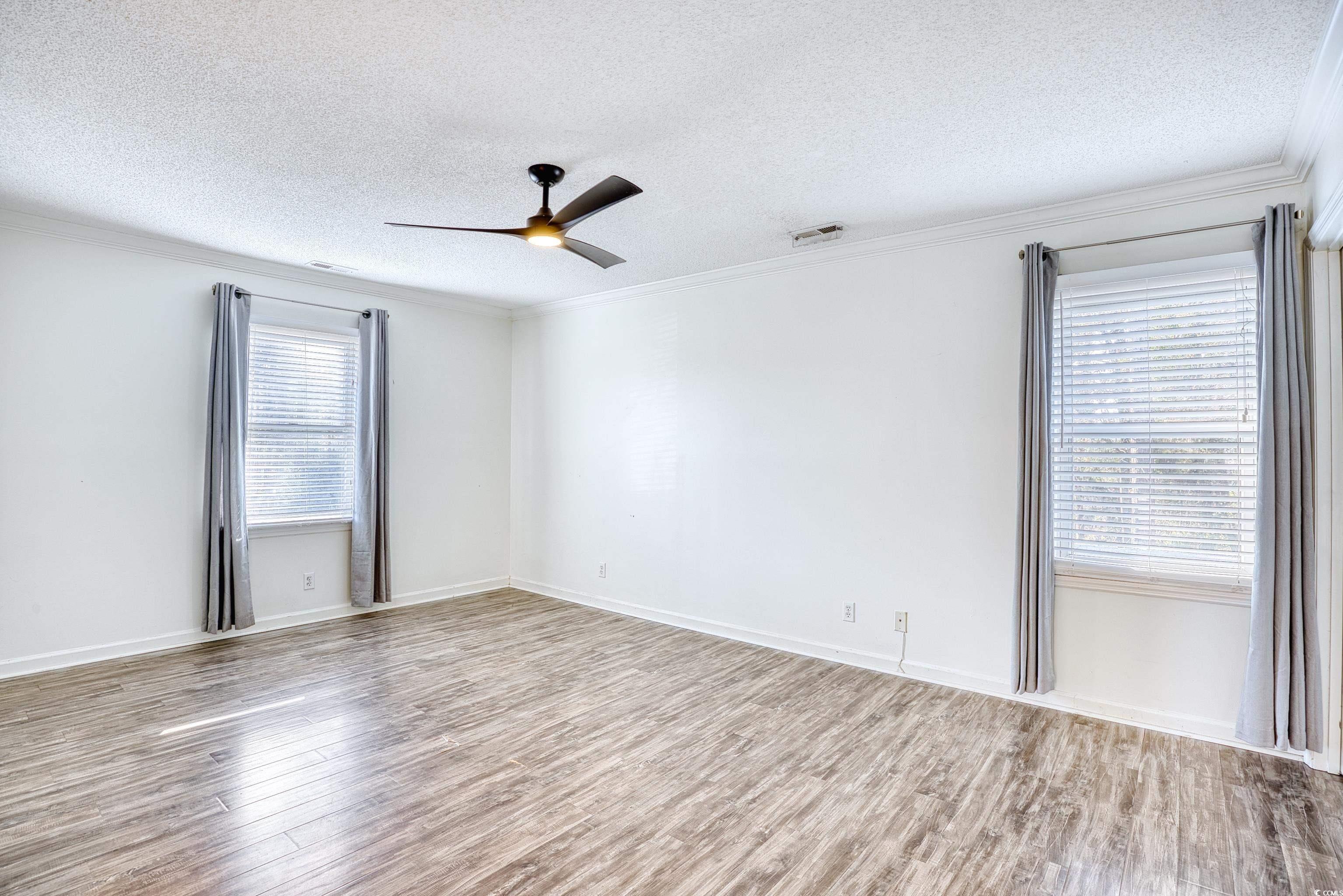 116 Great Lakes Road Pawleys Island, SC 29585 - Photo 19 of 37 Empty room featuring crown molding, a textured cei