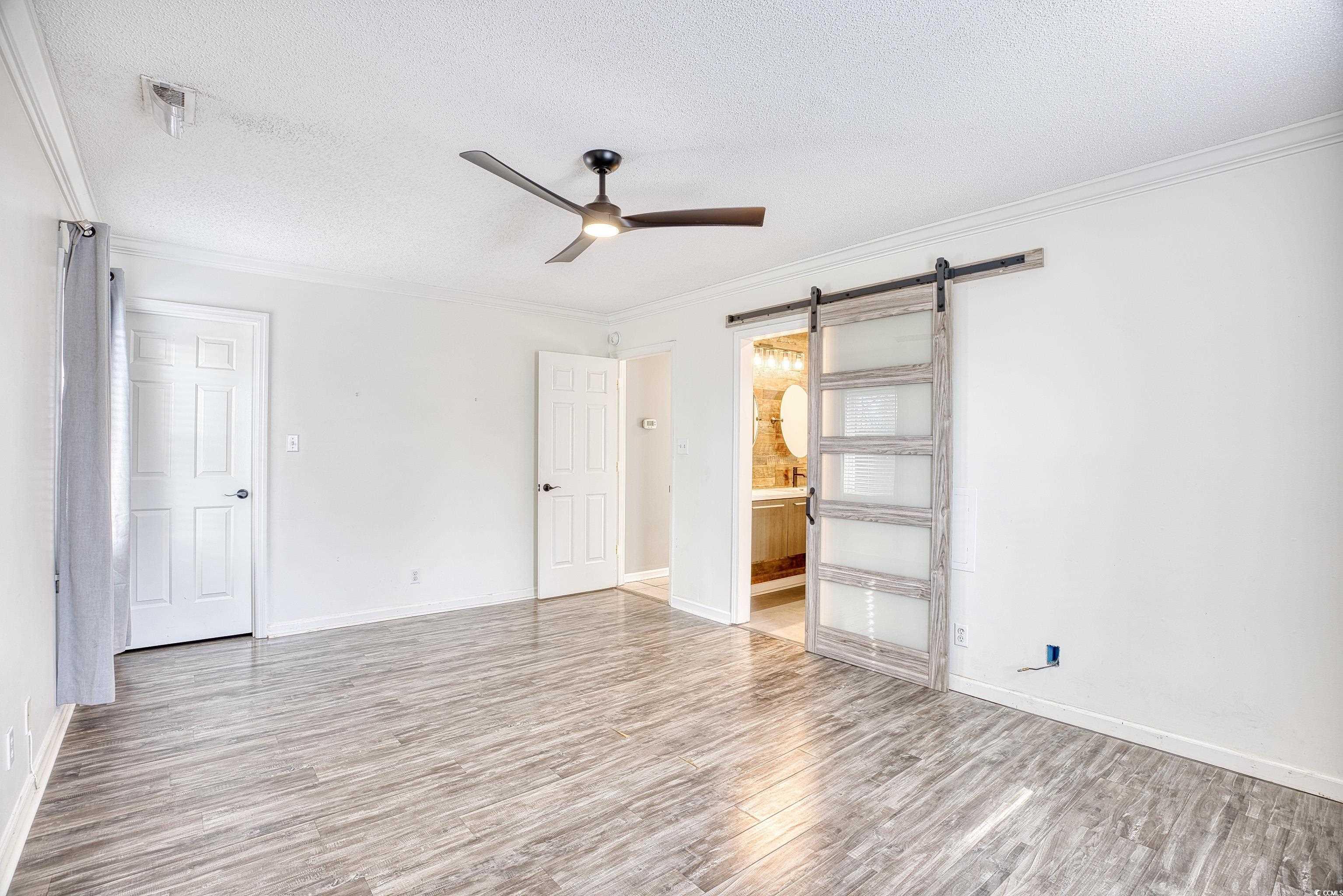116 Great Lakes Road Pawleys Island, SC 29585 - Photo 21 of 37 Empty room with ornamental molding, a barn door, a