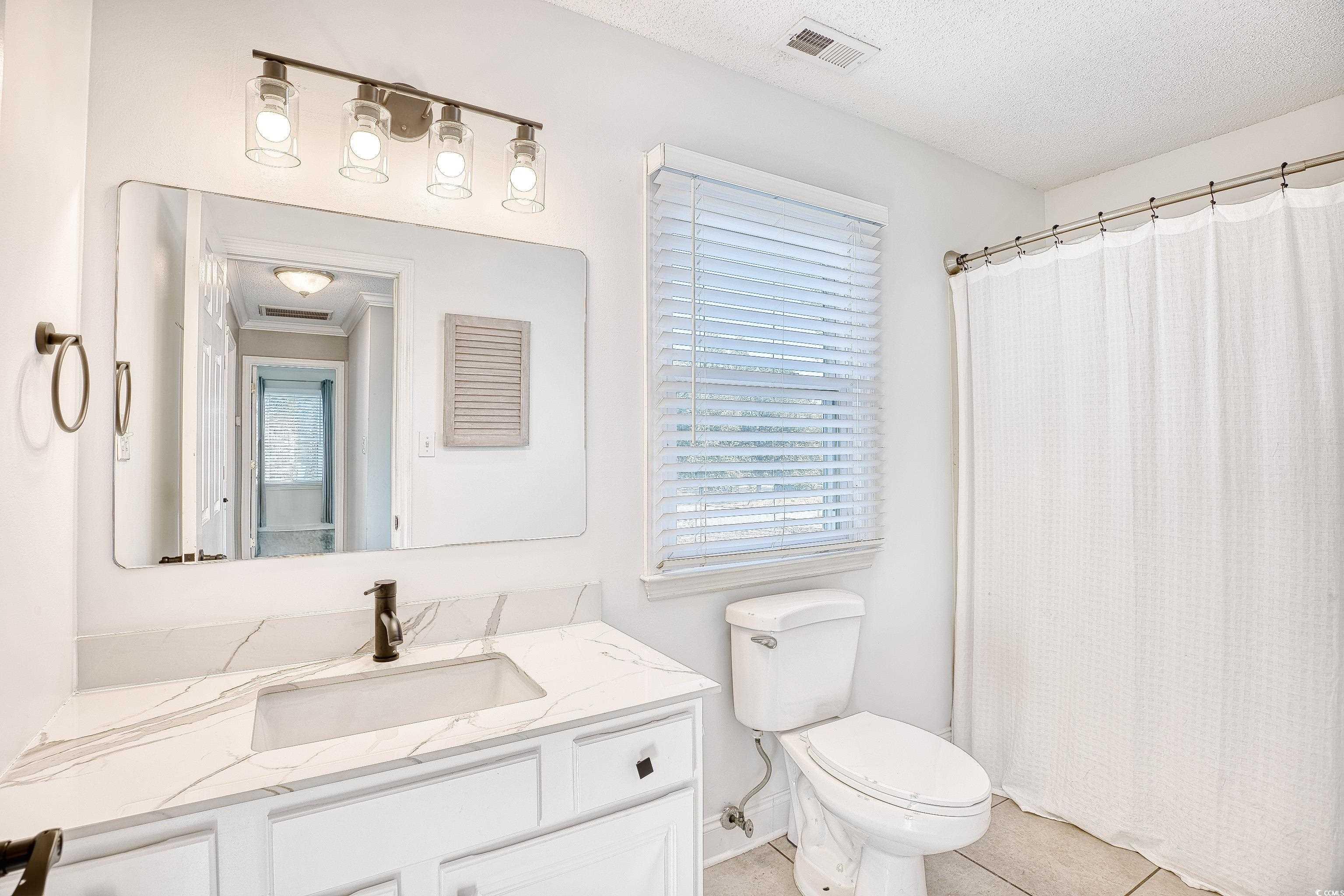 116 Great Lakes Road Pawleys Island, SC 29585 - Photo 26 of 37 Bathroom featuring vanity, toilet, tile patterned