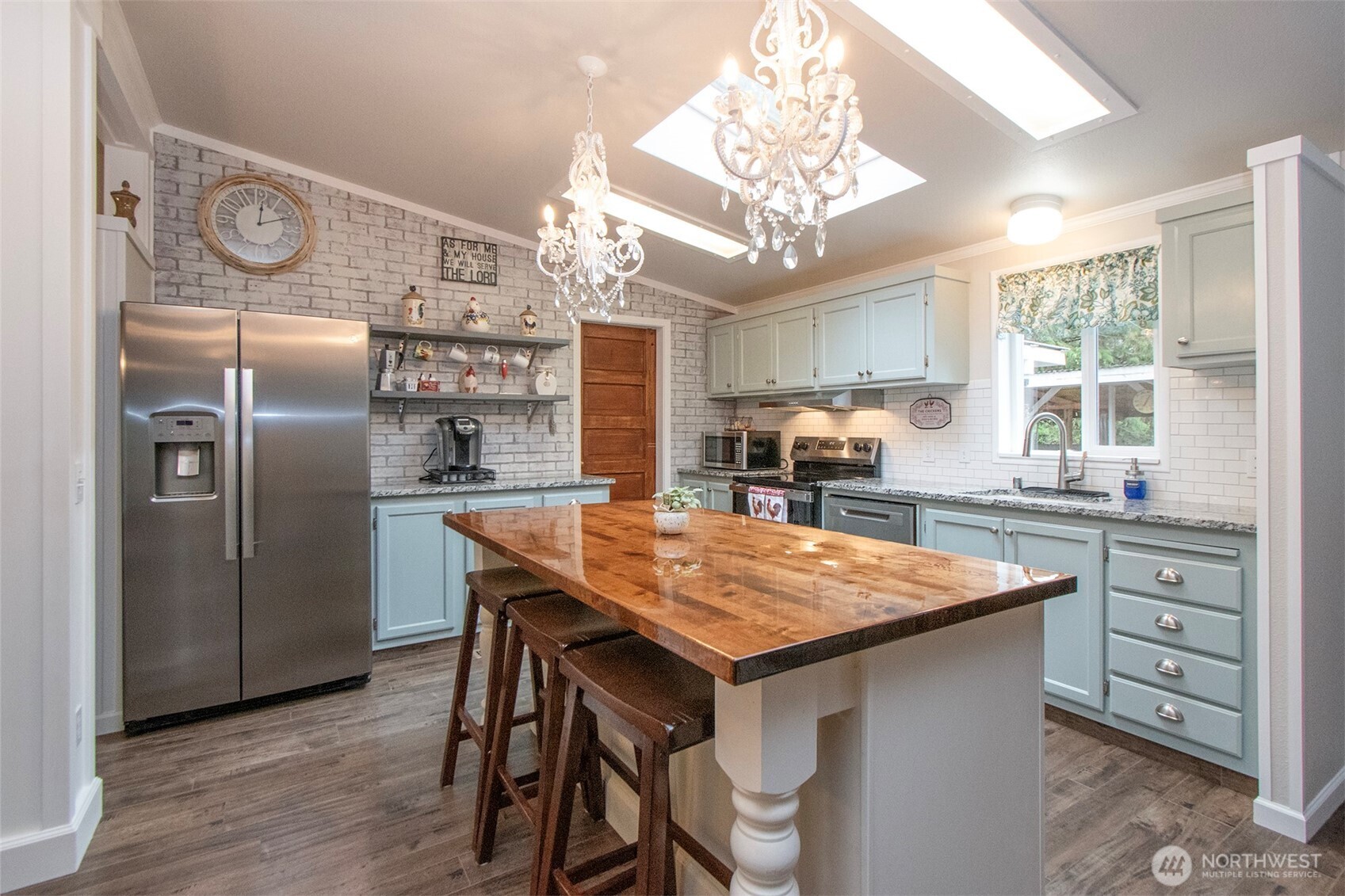 141 Lavender Ridge Lane Sequim, WA 98382 - Photo 13 of 40 a kitchen with stainless steel appliances granite countertop a table chairs a refrigerator and wooden cabinets