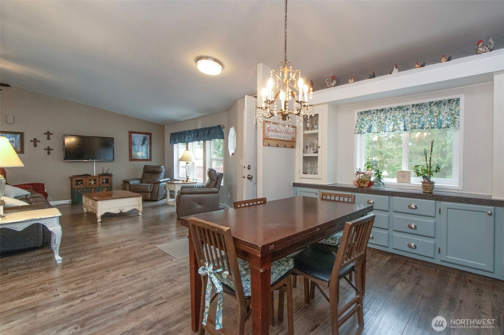 141 Lavender Ridge Lane Sequim, WA 98382 - Photo 17 of 40 a dining room with wooden floor a chandelier a wooden table and chairs