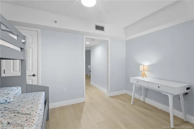 a bedroom with a bed and a lamp on dresser