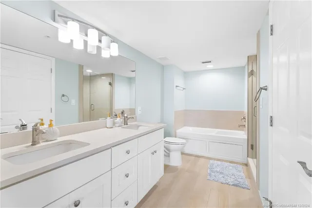 a bathroom with a tub a sink and a large mirror