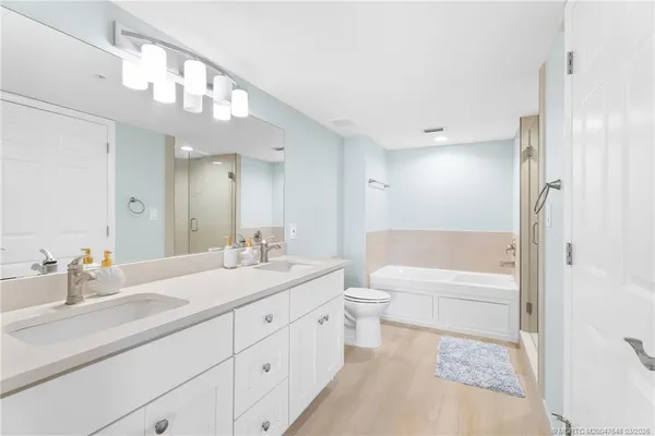 a bathroom with a tub a sink and a large mirror